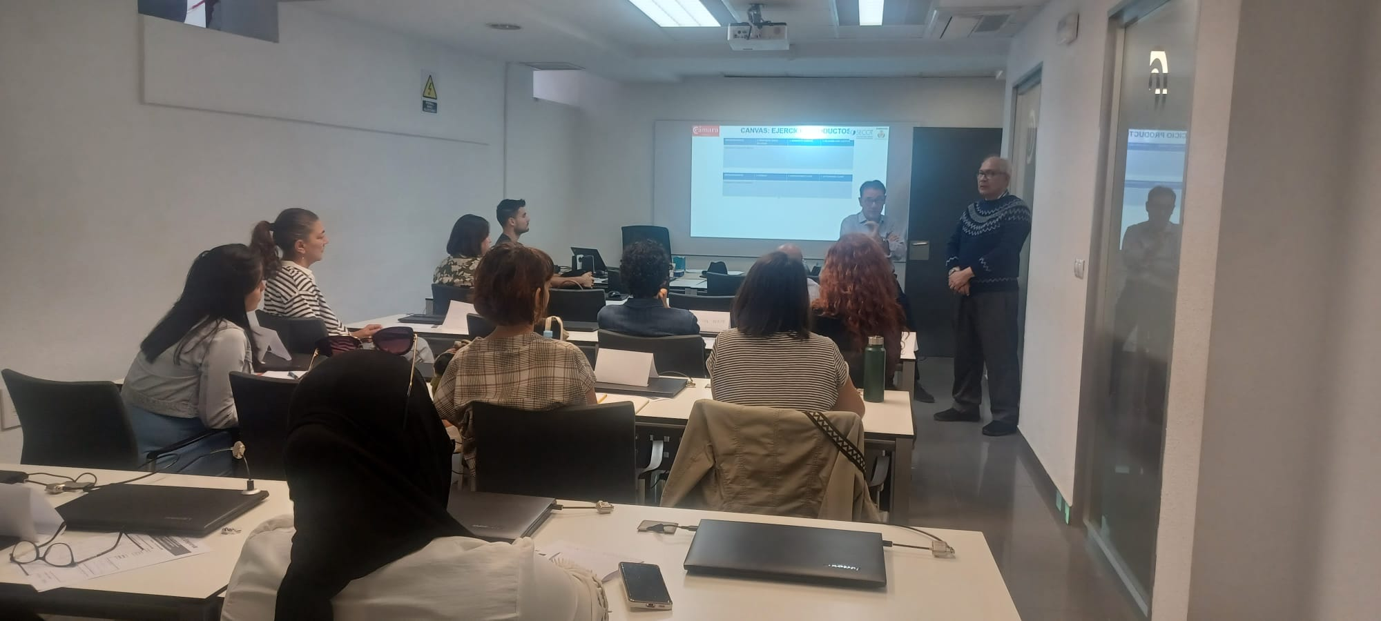 Participantes del Taller “Plan de Empresa” en la Cámara de Comercio de Valencia, durante la exposición guiada por los Séniors de SECOT Valencia sobre cómo transformar una idea en un proyecto viable.